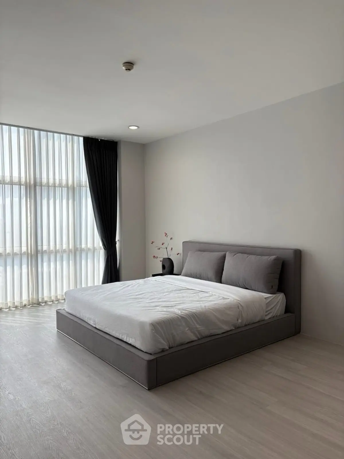 Modern minimalist bedroom with large window and elegant decor