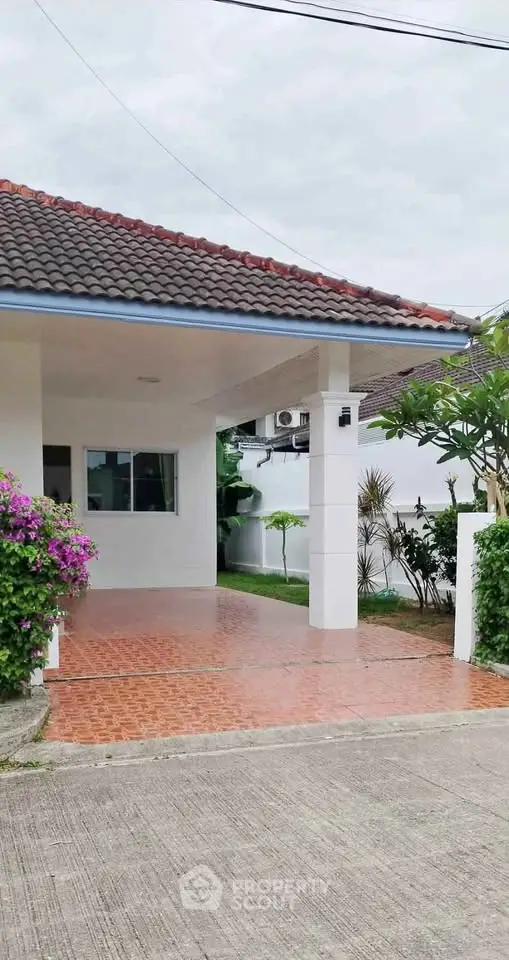 Charming suburban home with tiled driveway and lush greenery, perfect for family living.