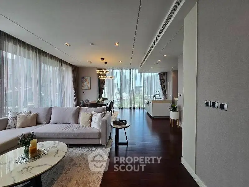 Luxurious open-plan living room with elegant decor and floor-to-ceiling windows offering stunning views.