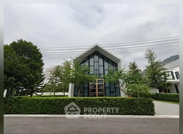 Modern architectural house exterior with lush greenery and sleek design.