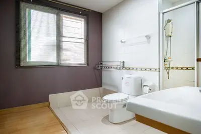 Spacious modern bathroom with natural light and elegant fixtures.