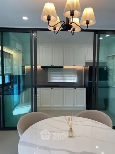 Modern kitchen with elegant dining area and stylish lighting