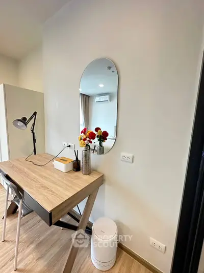 Modern study area with sleek desk, mirror, and stylish decor in a contemporary apartment.
