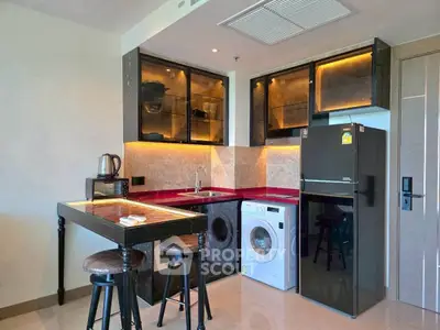 Modern kitchen with sleek black cabinets, washing machine, and stylish breakfast bar seating.