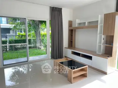 Spacious living room with modern furniture and large windows overlooking a lush garden.