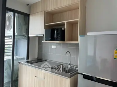 Modern kitchen with sleek cabinetry and stainless steel appliances in a compact layout.