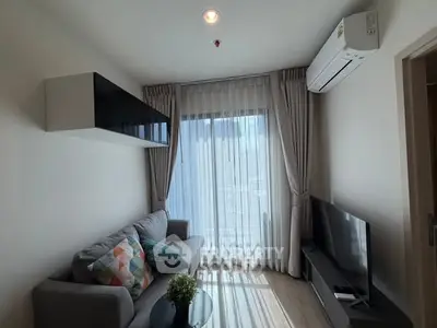 Modern living room with cozy sofa, large window, and sleek TV setup in a stylish apartment.