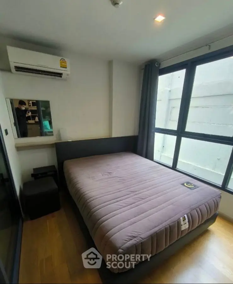 Modern bedroom with large window and air conditioning unit