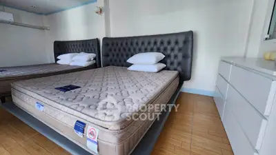 Spacious bedroom with two large beds and modern dresser, perfect for comfort and relaxation.