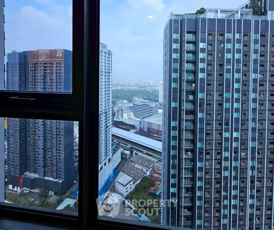 Stunning high-rise cityscape view from a modern apartment window, showcasing urban living at its finest.