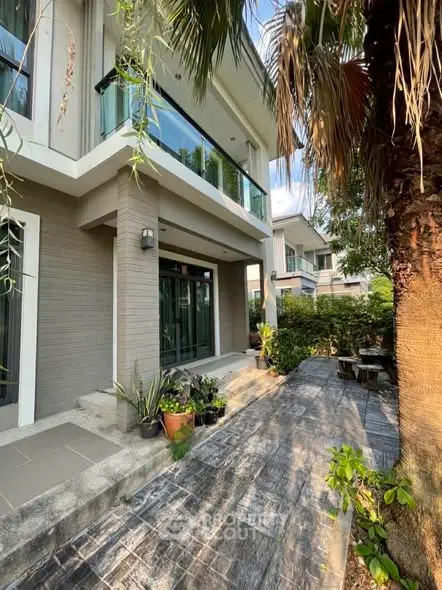 Modern two-story house with lush garden and spacious patio area