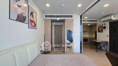 Modern bedroom with stylish decor and open kitchen layout in a contemporary apartment.