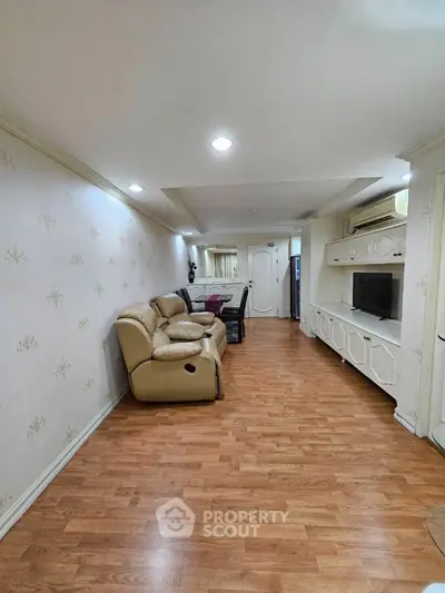 Spacious living room with elegant wooden flooring and cozy seating area.