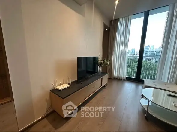 Modern living room with sleek TV stand and large window offering city view