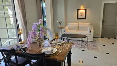 Elegant living room with dining area, featuring stylish decor and natural light.
