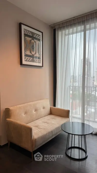 Modern living room with cozy beige sofa and city view through large window.