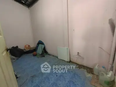 Unfurnished room with blue tile flooring and pink walls, ideal for storage or renovation.