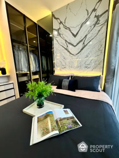 Luxurious bedroom with elegant marble accent wall and modern closet design.