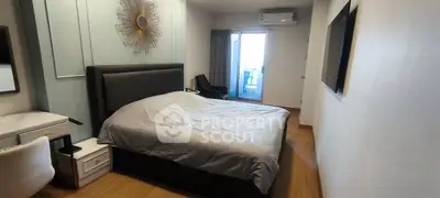 Modern bedroom with stylish decor and balcony access in a contemporary apartment.