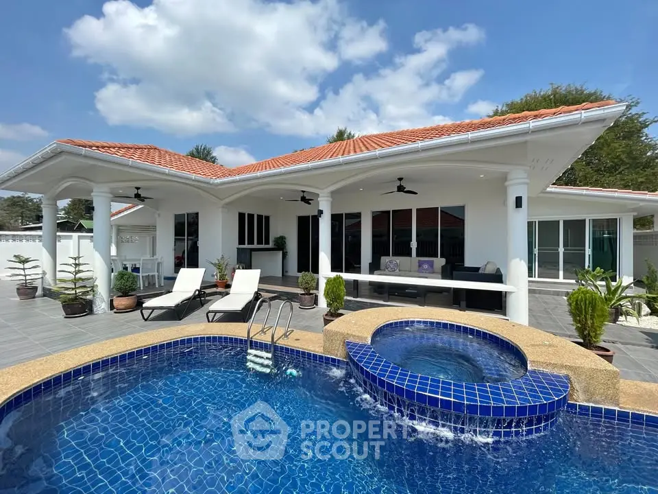 Luxurious villa with private pool and spacious patio under clear blue skies.