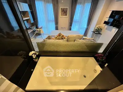 Luxurious open-plan living room with bathtub view, modern decor, and elegant furnishings.