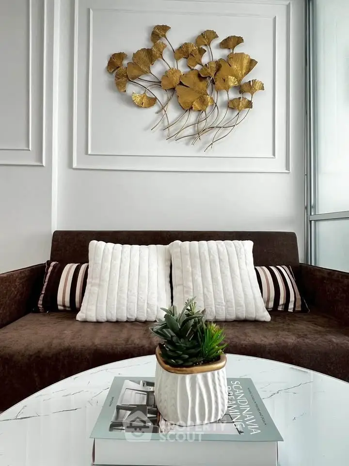Elegant living room with stylish decor and cozy seating area, featuring modern wall art and plush cushions.