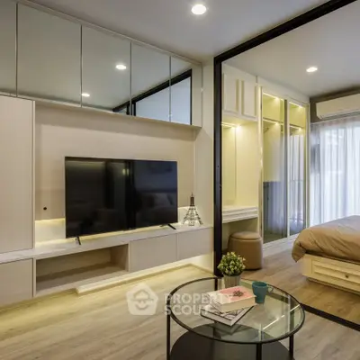 Modern open-plan living room with sleek TV unit and cozy bedroom view.