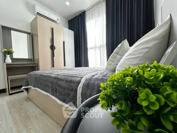 Modern bedroom with stylish decor and natural light, featuring a cozy bed and elegant furnishings.