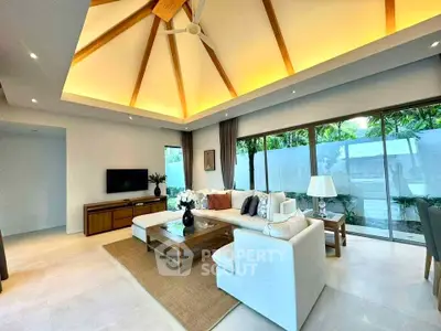 Luxurious living room with high ceiling and modern decor, featuring large windows and stylish furniture.