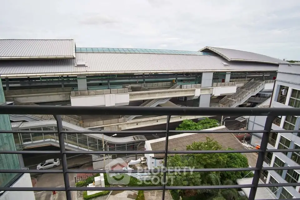 Modern building exterior with multiple levels and green landscaping, showcasing urban architecture.