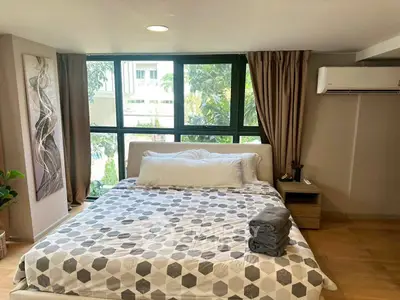 Spacious bedroom with large windows and modern decor in a stylish apartment.