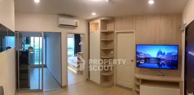 Modern living room with built-in shelves and wall-mounted TV, leading to a balcony with city view.