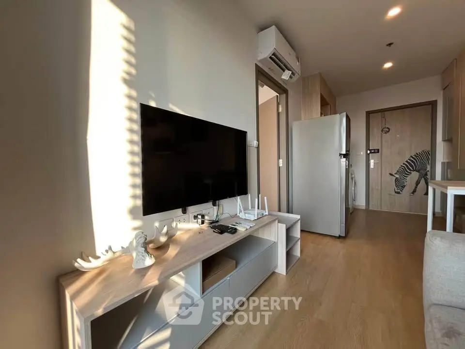 Modern living room with sleek TV setup and stylish decor in a cozy apartment.