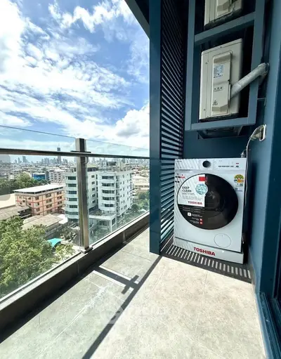 Modern balcony with city view and washing machine, perfect for urban living.