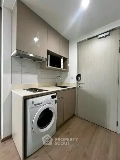 Modern compact kitchen with washing machine and sleek cabinetry