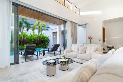 Luxurious open-plan living room with poolside view and lush garden, perfect for relaxation and entertaining.