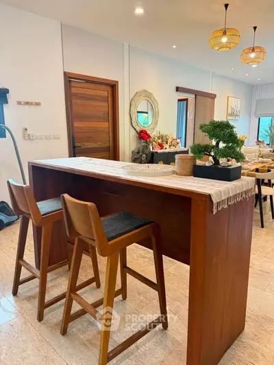 Modern dining area with stylish wooden bar table and chairs, featuring elegant decor and natural lighting.