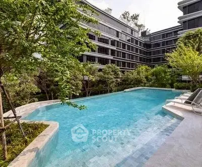 Luxurious residential building with a stunning outdoor pool surrounded by lush greenery.
