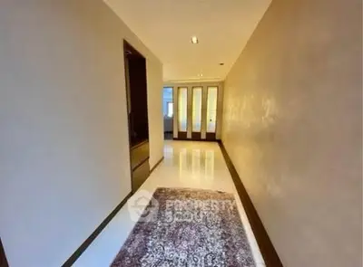 Spacious hallway with elegant rug and modern lighting