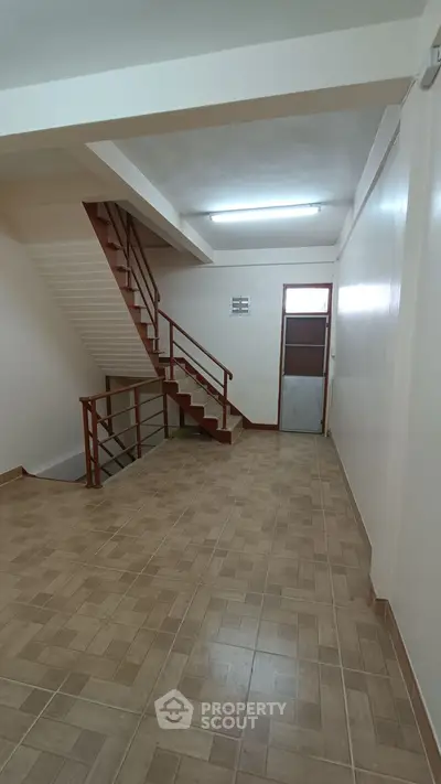 Spacious interior with staircase and tiled flooring, ideal for versatile use.