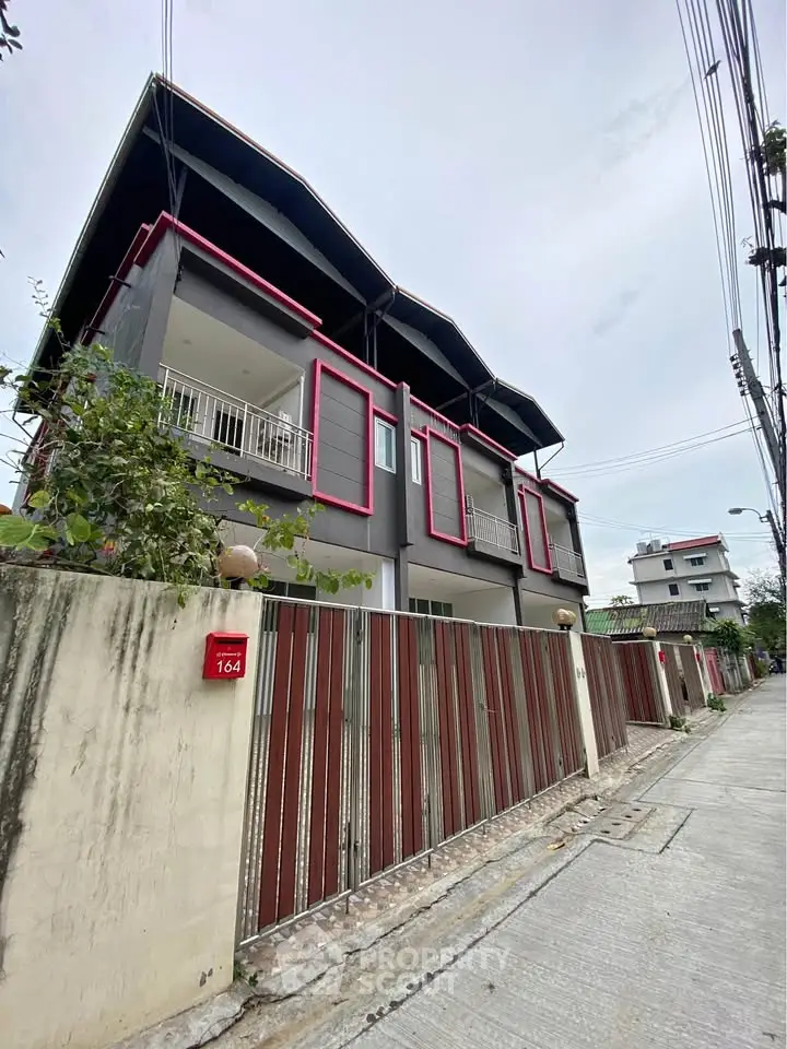 Modern townhouse with unique architectural design and spacious balcony in urban neighborhood.