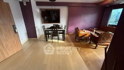 Spacious living room with elegant wooden furniture and large window view.