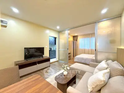 Modern open-plan living room with cozy seating and bedroom view
