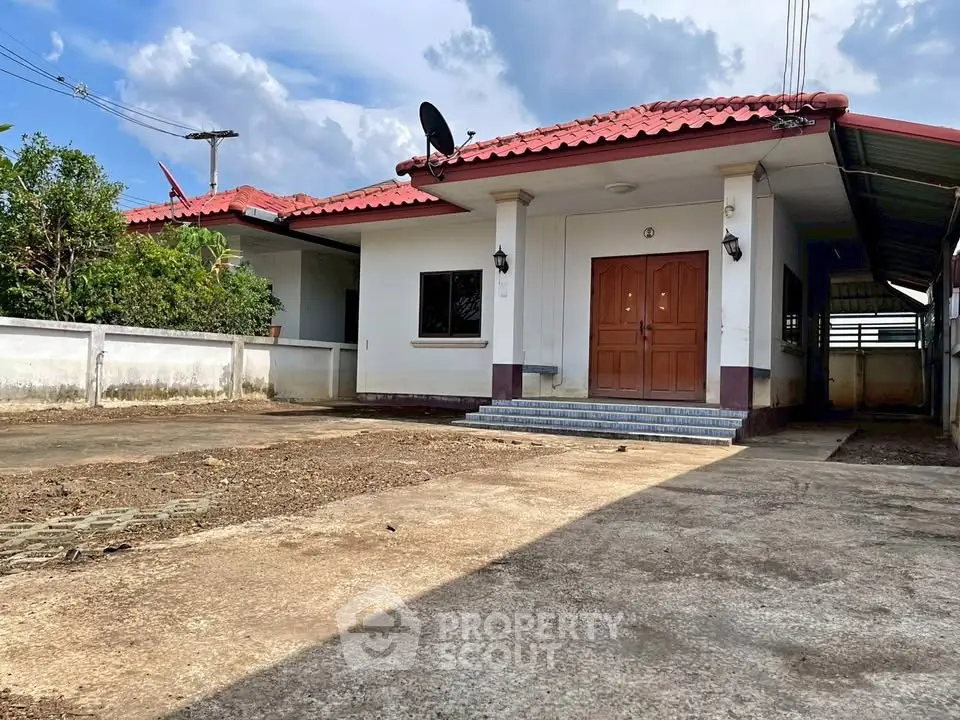 Charming single-story house with red-tiled roof and spacious driveway, perfect for family living.