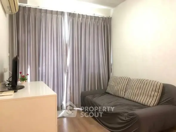 Cozy living room with modern sofa and elegant curtains, perfect for relaxation.