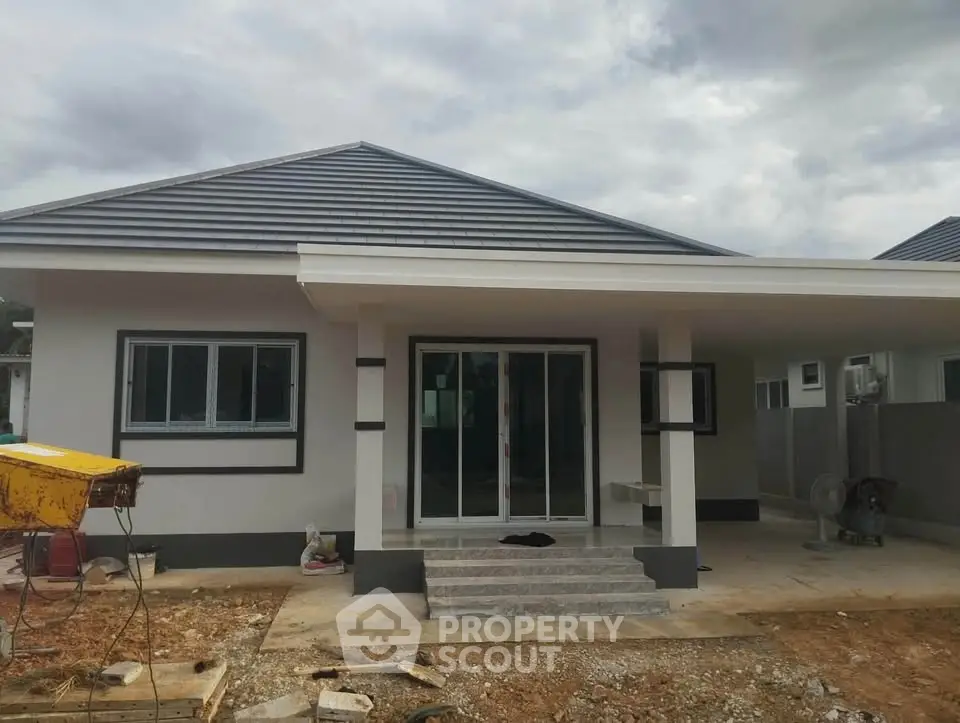 Modern single-story house with sleek design and spacious front porch, perfect for family living.