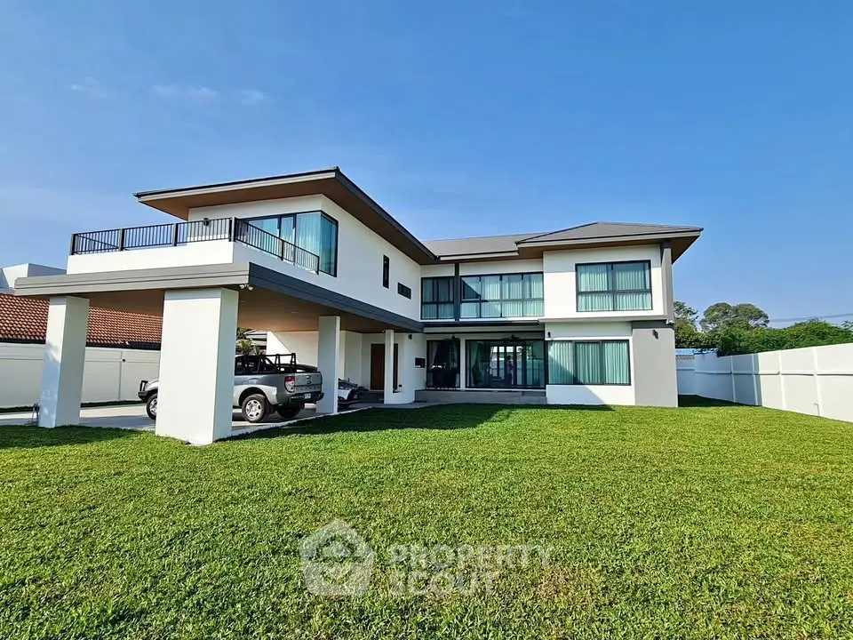 Stunning modern two-story house with spacious lawn and sleek architectural design.