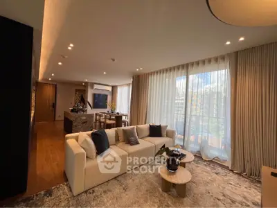 Luxurious living room with elegant decor and large windows offering natural light and a view of the balcony.