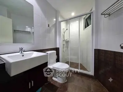 Modern bathroom with sleek fixtures and glass shower enclosure in a contemporary home.