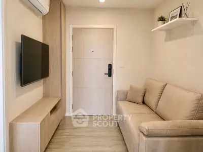 Cozy modern living room with beige sofa, wall-mounted TV, and stylish decor.